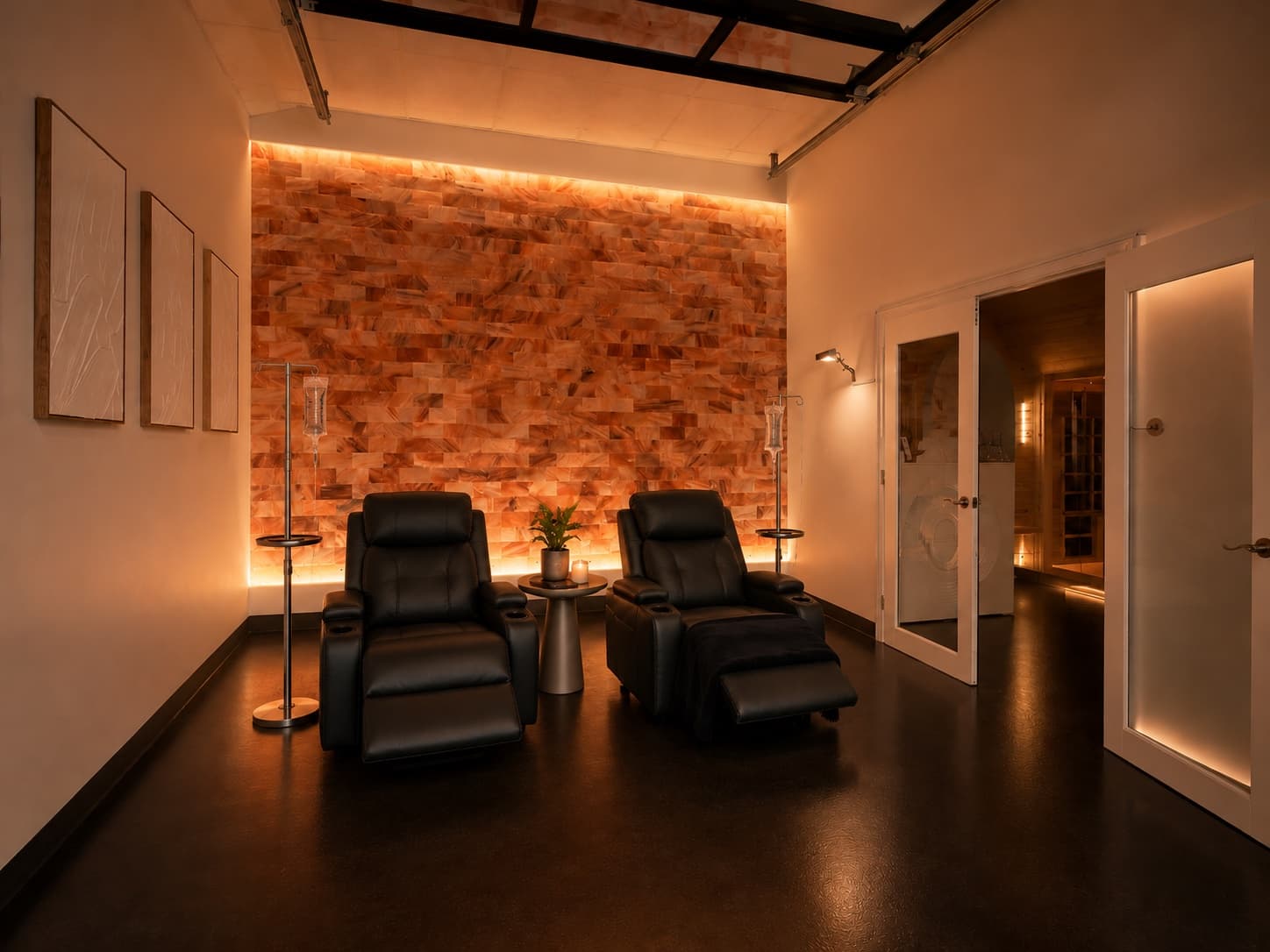 IV therapy lounge with leather recliners, IV drip stands, and a backlit salt stone wall